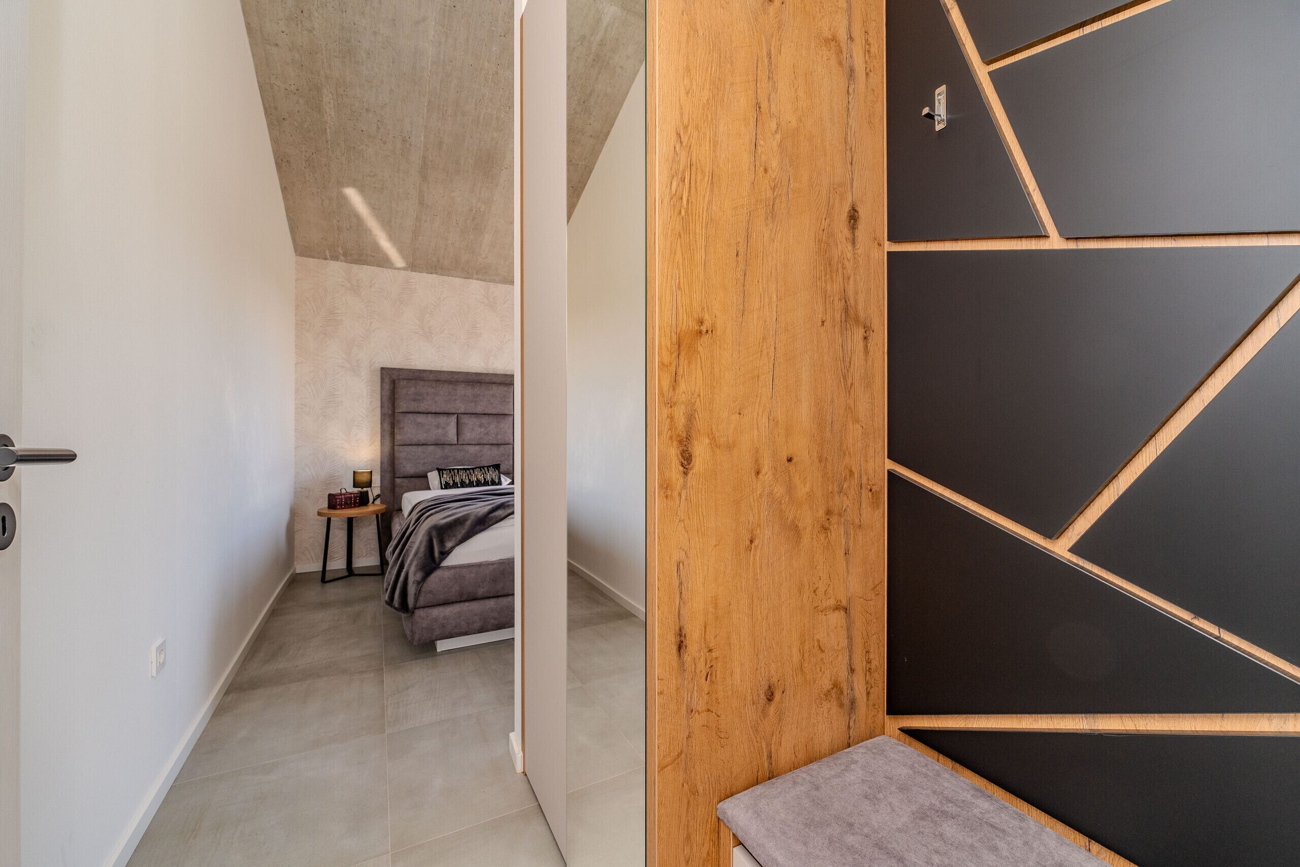 A modern bedroom with a bed, bedside table, and a nightstand.