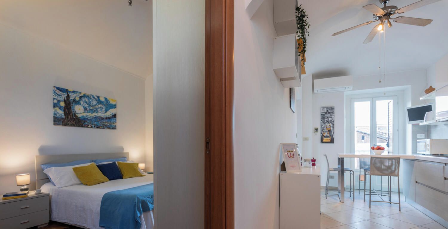 Un dormitorio con cama, mesita de noche y un cuadro en la pared.