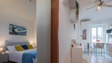 Un dormitorio con cama, mesita de noche y un cuadro en la pared.