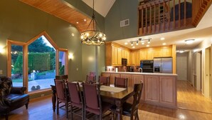 A spacious kitchen with wooden cabinets, a central island, and modern appliances. - Eagle's Nest Lodge and Apts (Whittier)