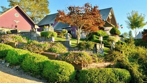 A residential area with houses featuring stone foundations and well-maintained gardens. - Eagle's Nest Lodge and Apts (Whittier)
