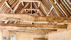 Une piscine intérieure avec un mur en pierre et des poutres en bois au plafond.