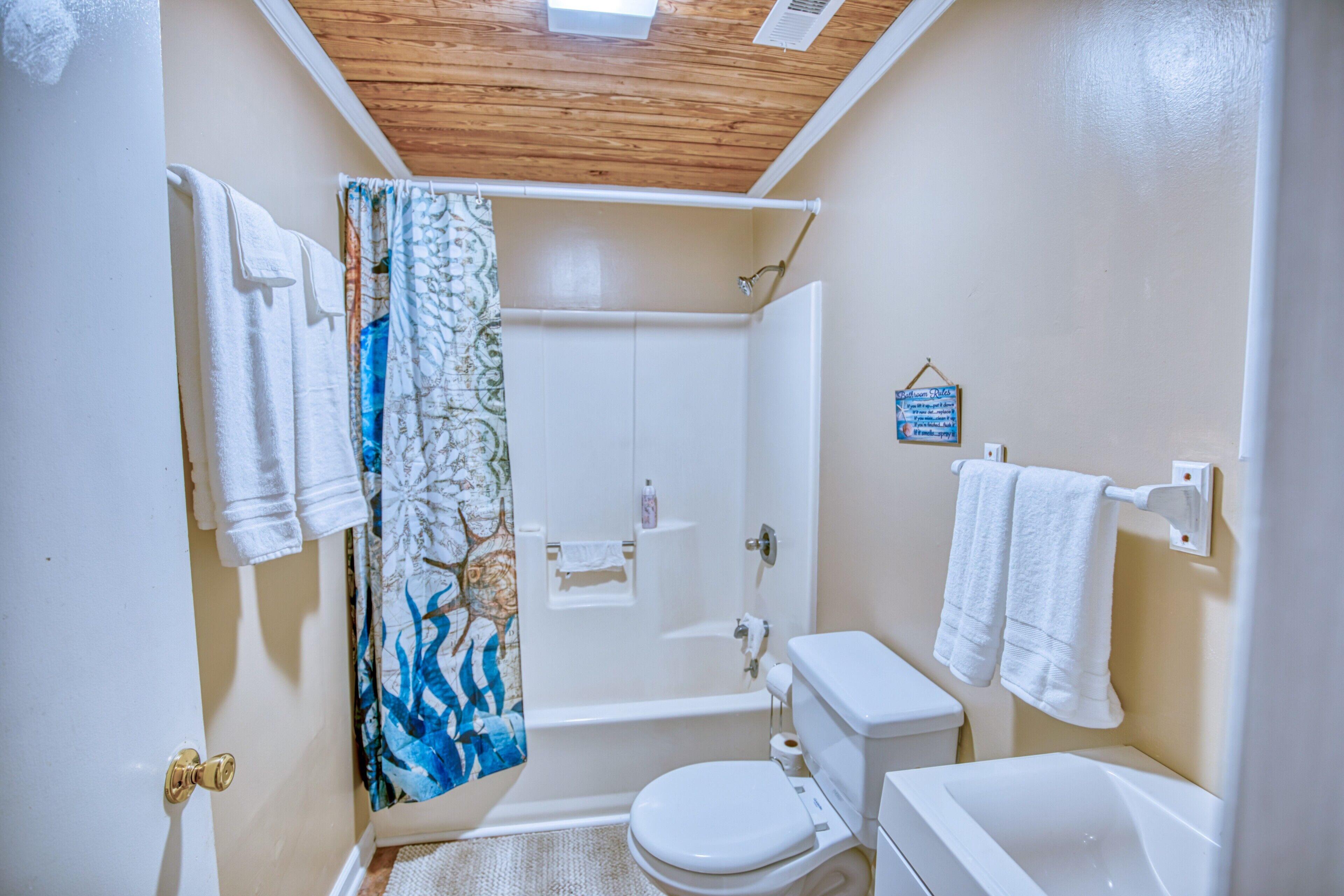 A compact bathroom with a shower, toilet, and sink.