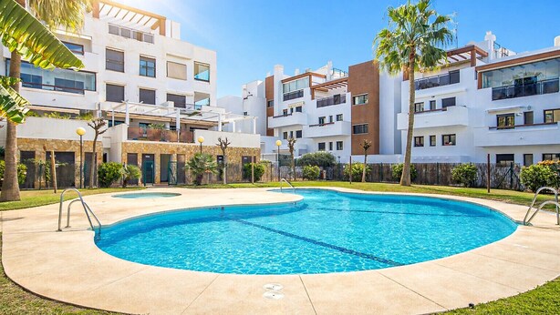 A modern apartment complex with a central swimming pool, surrounded by greenery and palm trees. - Calablanca walking distance to La Cala and beach (La Cala de Mijas)