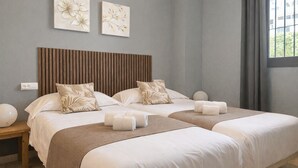 A hotel room with two beds, a wooden headboard, a bedside table, and a window with curtains. - Calablanca walking distance to La Cala and beach (La Cala de Mijas)