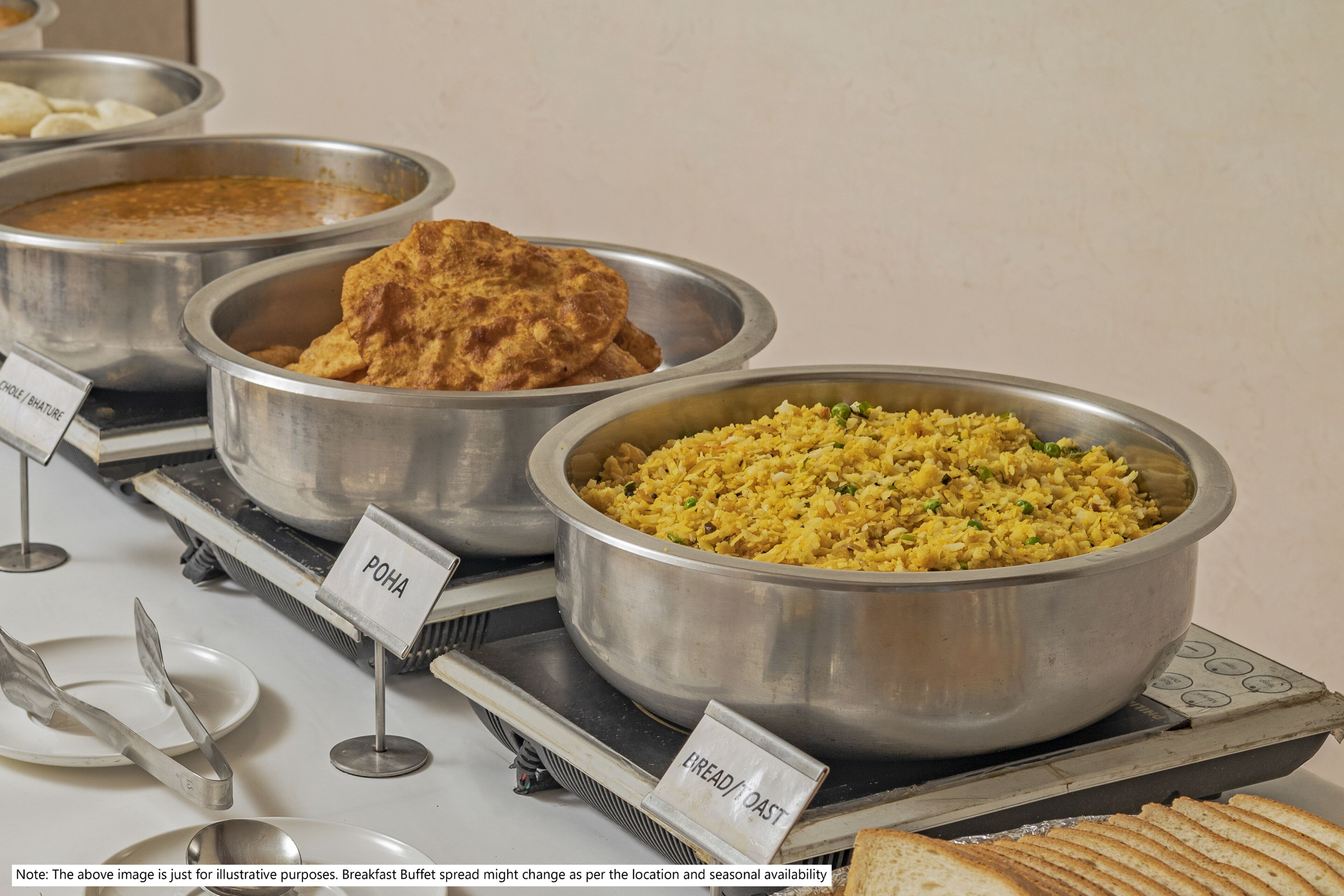 A buffet with labeled dishes including POHA, LEMONADE, and bread.