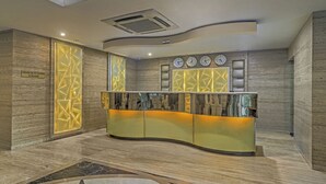 Un espace d’accueil doté d’un comptoir incurvé, de plusieurs horloges et d’un panneau indiquant les restrictions applicables aux visiteurs.