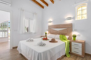 Ein Hotelzimmer mit einem Bett, Nachttischen, einem Fenster und Blick nach außen.