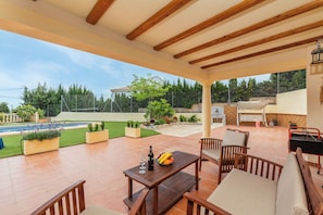 Uma área de varanda coberta com piscina, área de estar externa e vista para a paisagem ao redor.