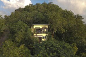 Escape to a serene retreat amidst lush forest surroundings, with a balcony offering breathtaking views of the natural landscape.