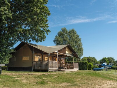 Experience luxury glamping in the elevated Safari Tent Ranger by the water.