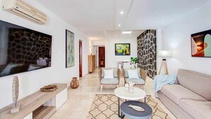 A modern living room with a flat-screen TV, a sofa, a coffee table, and a dining area. - Homo Aura. Villa with private pool in Playa Blanca (Playa Blanca (Yaiza))