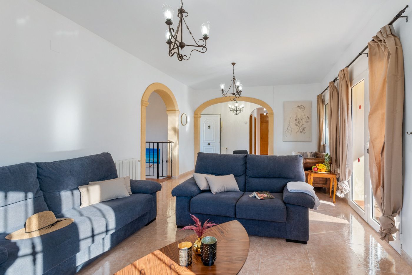Ein modernes Wohnzimmer mit zwei Sofas, einem Couchtisch und einer Kristallleuchtre.