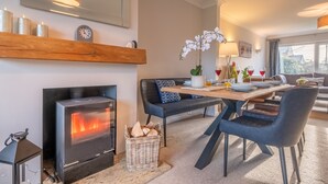 Ein gemütliches Wohnzimmer mit Kamin, einem Essbereich mit Tisch und Stühlen sowie einem großen Fenster mit Aussicht.