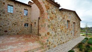 A stone building with a brick pathway leading to a door.