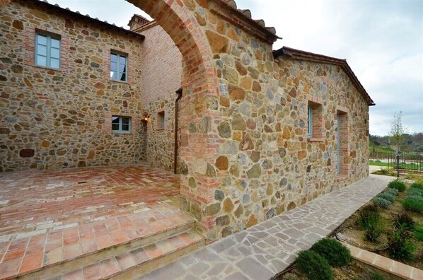 A stone building with a brick pathway leading to a door.