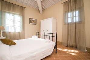 A bedroom with a bed, a wardrobe, a window with curtains, and a picture on the wall. - Apartment In A Hotel 'Appartamento Cipresso' with Shared Pool, Wi-Fi and Air Conditioning (Trequanda)