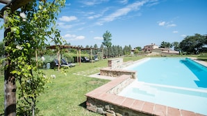 A swimming pool with a stone border, a pergola with climbing plants, and a grassy area with lounge chairs. - Hotel Apartment "Quercia" with Shared Pool & Wi-Fi (Trequanda)