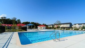 Une piscine dotée d’un poste de surveillance pour les sauveteurs, entourée d’une clôture et comprenant un espace de repos abrité.