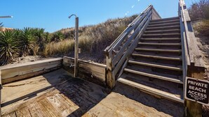 A wooden staircase leading to a private beach area with a sign indicating private access. - Topsail Pearl #132 – Oceanfront Retreat with Beach Access & Sound Views (North Topsail Beach)