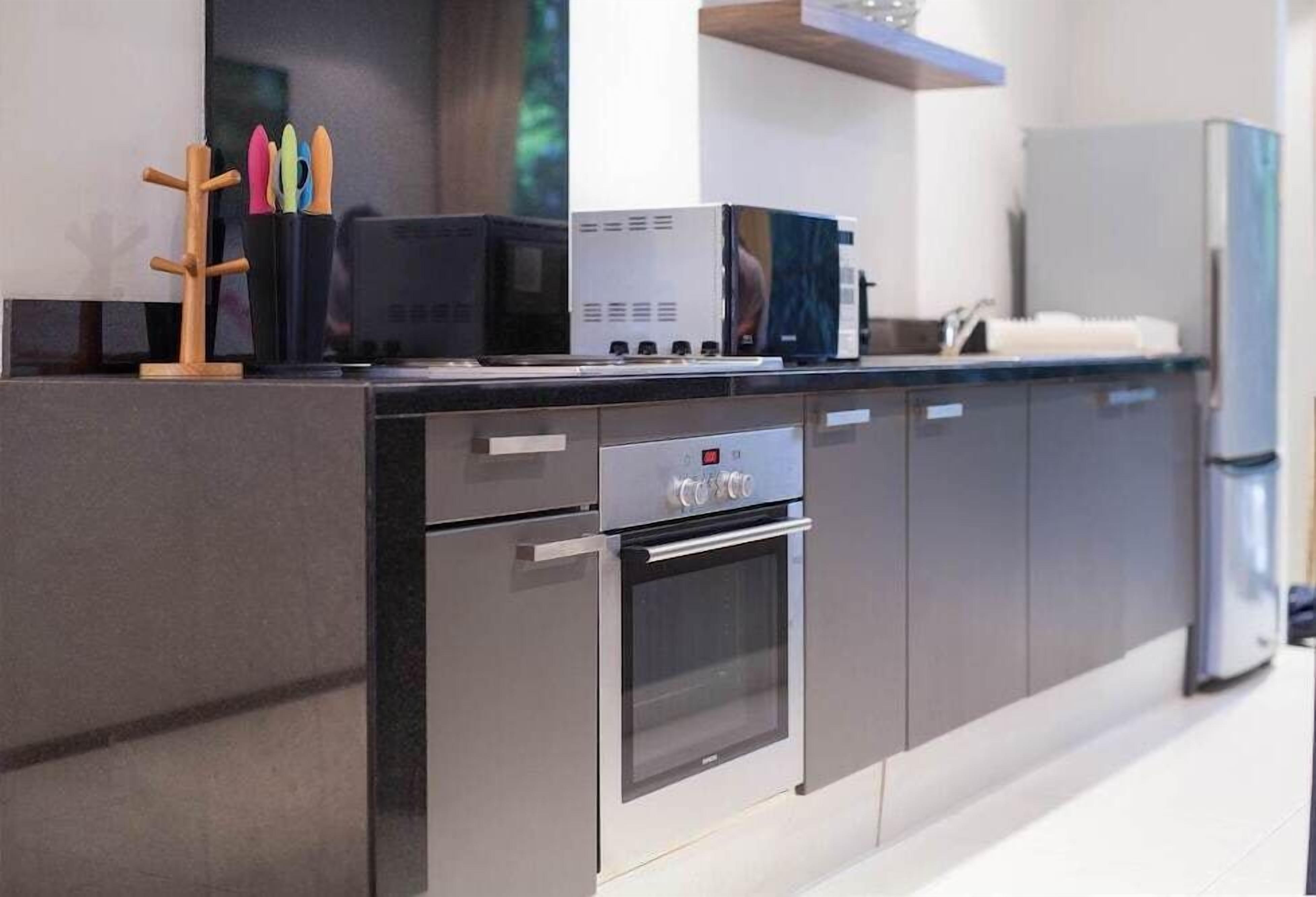 A modern kitchen with stainless steel appliances, a built-in oven, and a microwave.