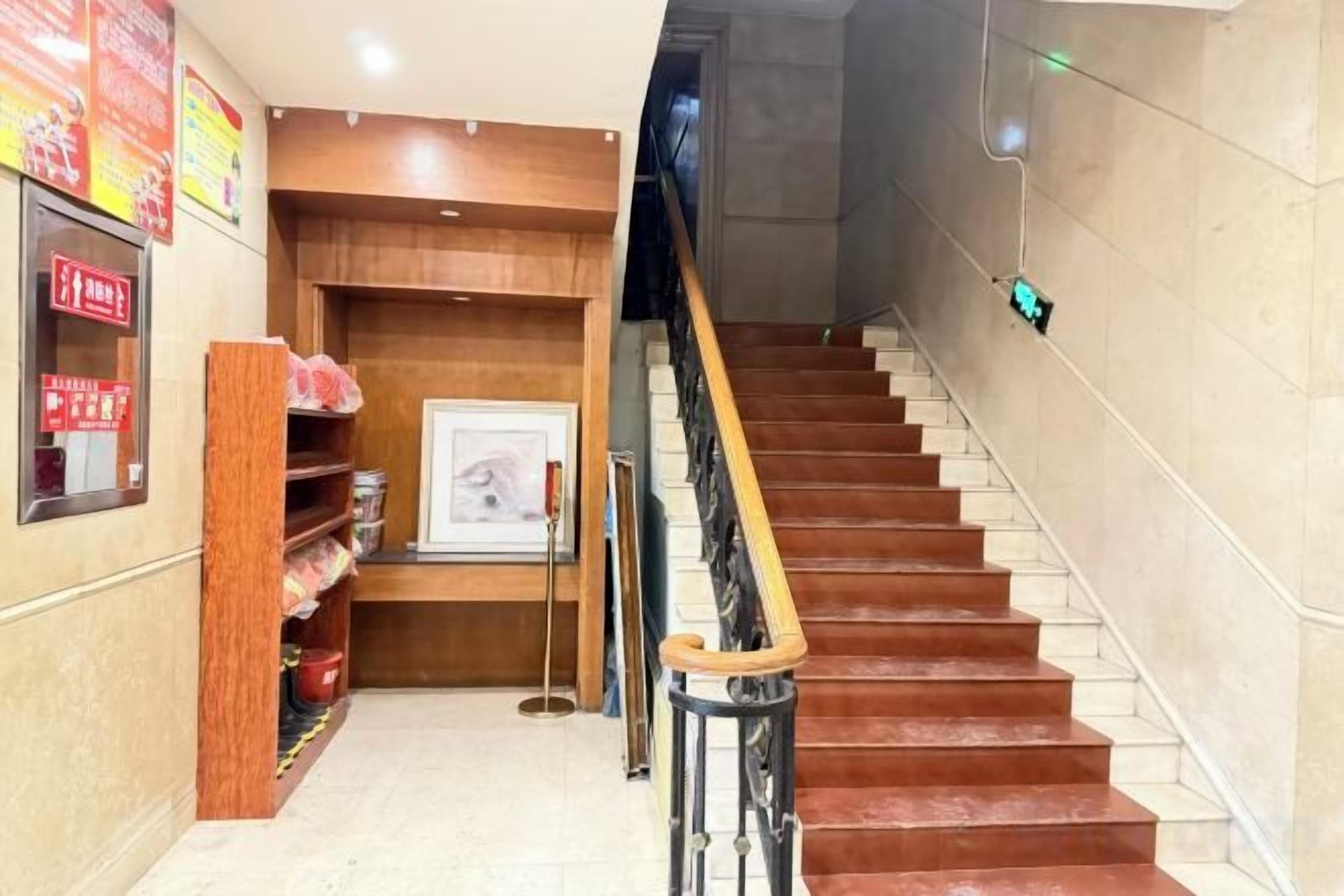A staircase with wooden handrails and a tiled wall.