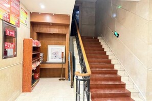 A staircase with wooden handrails and a tiled wall. - Kocemo Hotel (Yanji)