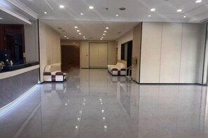 A spacious lobby with a polished floor, seating area, and a door leading to another room. - Kocemo Hotel (Yanji)