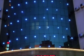 A modern building with a reflective glass facade and numerous small lights. - Kocemo Hotel (Yanji)