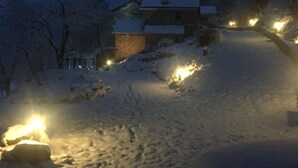 A snow-covered landscape with a house and a pathway.