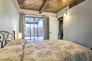 A bedroom with a large bed, a wooden ceiling, a sliding glass door leading outside, and a white door to a closet. - Gateway to Mt Rose Ski! Reno Home w/ Fireplace (Reno)