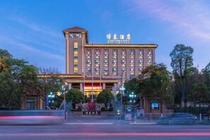 A large hotel with multiple floors, a prominent entrance, and a well-lit facade. - Botai Hotel (Qujing)