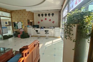Un área de recepción con mostrador, sillas y una pared con un letrero.