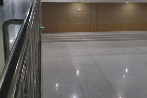 Ein sauberer, gefliester Boden mit Metallgeländer und einer Wand mit Holzelementen.