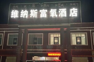 A building with a sign that reads '维纳斯富氧酒店' and another sign below it that says '常温酒店'.