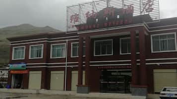 Un edificio con letrero, varias ventanas y puerta de garaje.