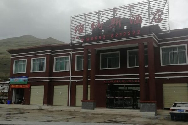 A building with a signboard, multiple windows, and a garage door.