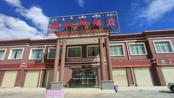 A hotel with a prominent signboard, multiple windows, and a covered entrance area.