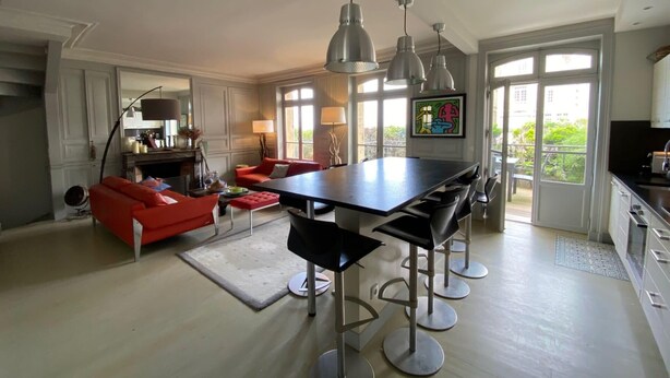 A spacious living area with a large dining table, red sofa, and modern pendant lights. - House with sea view next to the beach (Trouville-sur-Mer)