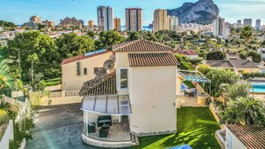 Um imóvel residencial com varanda, piscina e vista para a cidade e montanhas.