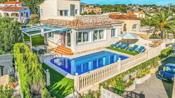 Uma villa em estilo mediterrâneo com piscina, área de estar externa e vista para o bairro.