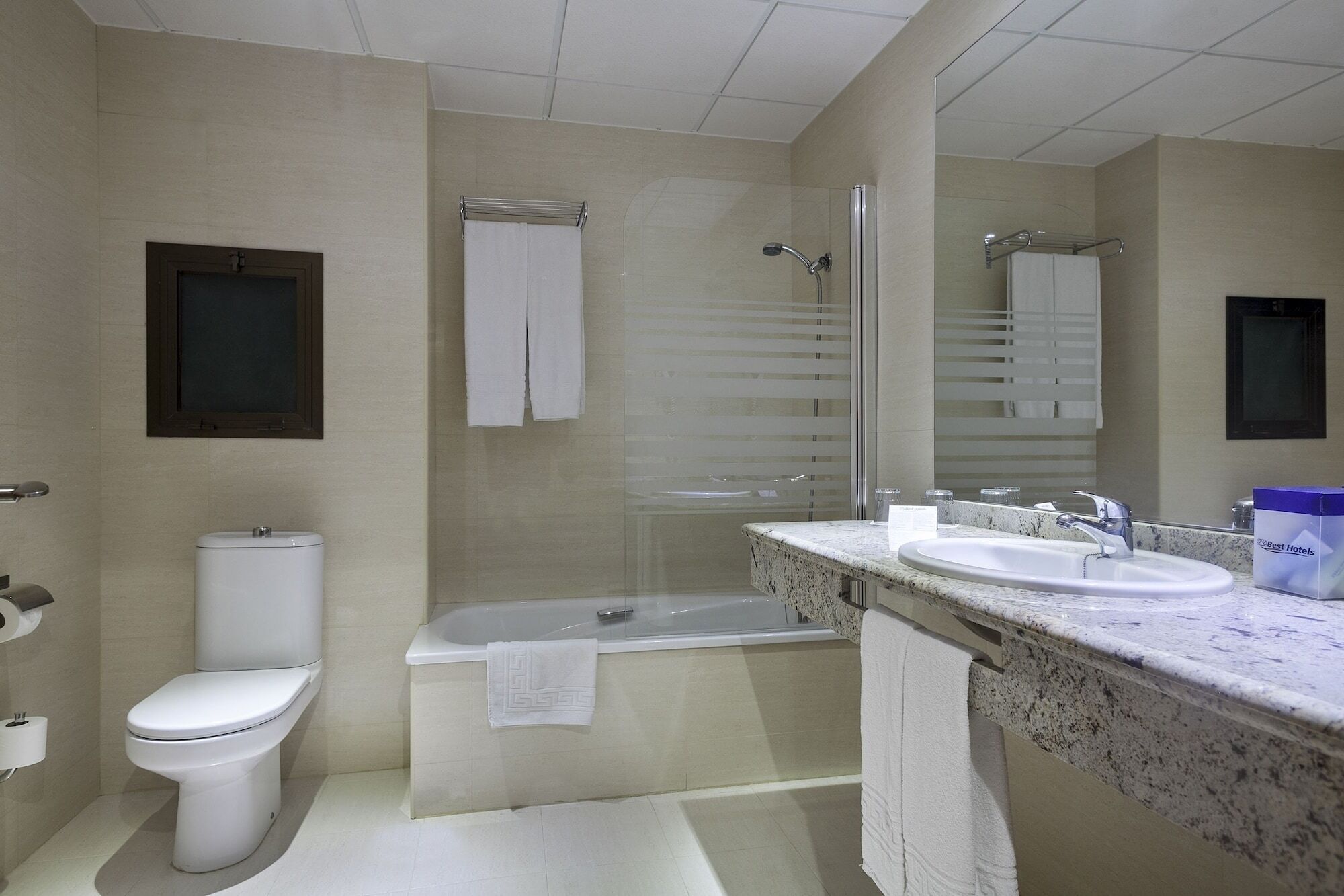 A modern bathroom with a toilet, bathtub, shower, and a vanity with a sink.