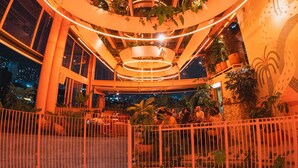 A circular atrium with a central skylight, surrounded by plants and illuminated by warm lighting. - The Somos Bold Hotel (Medellín)