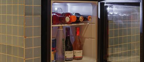 Un petit réfrigérateur doté d’un verrouillage numérique et contenant diverses bouteilles de boissons.