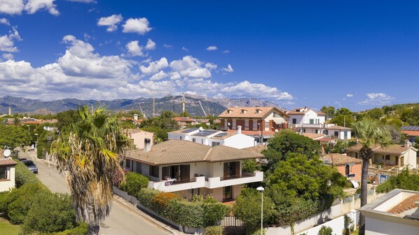 Un quartier résidentiel avec des maisons, des panneaux solaires et une chaîne de montagnes en arrière-plan.