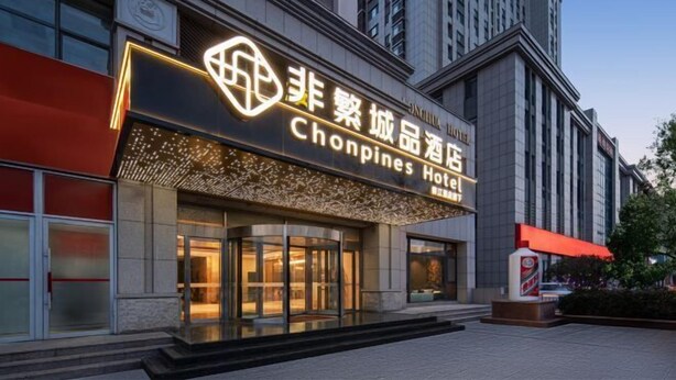 A hotel entrance with a prominent sign in both English and Chinese, indicating it is the Chongpines Hotel. - Chonpines Hetel (Qingdao Jimo Hetel) (Qingdao)