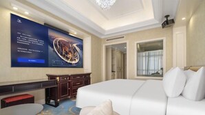 A hotel room with a large bed, a desk, a chair, a TV screen, and a window with curtains. - Chonpines Hetel (Qingdao Jimo Hetel) (Qingdao)