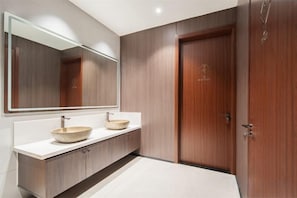 Une salle de bain moderne avec un meuble-lavabo en bois, deux vasques et un grand miroir.