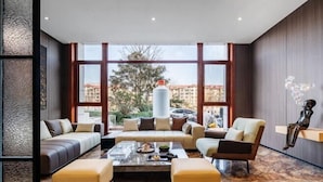 A modern living room with a sofa set, a coffee table, and a decorative sculpture. - Chonpines Hetel (Qingdao Jimo Hetel) (Qingdao)