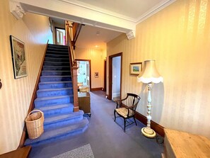 Staircase leads to an upper level, with a seating area and ambient lighting.
